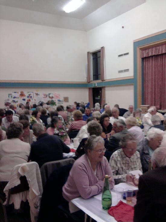 residents at a harvest meal in the village hall